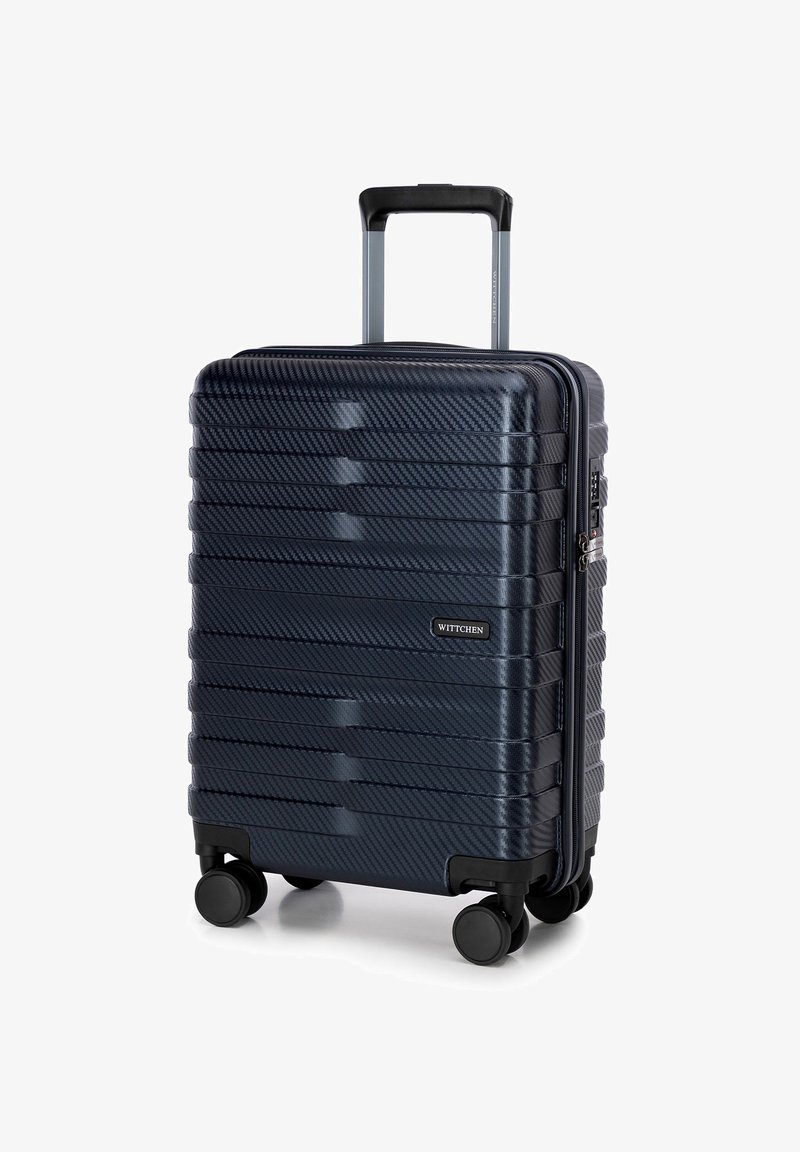 Tvrzený kufr v tmavě modré barvě s texturovanými horizontálními pruhy, s výsuvnou rukojetí, čtyřmi černými kolečky a zamykatelným zipem.
