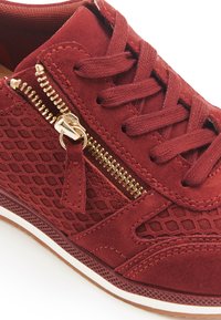 Sneaker in suede rosso con pannello in mesh testurizzato, dettagli in zip dorati e suola ammortizzata. Design con lacci e occhielli rinforzati.