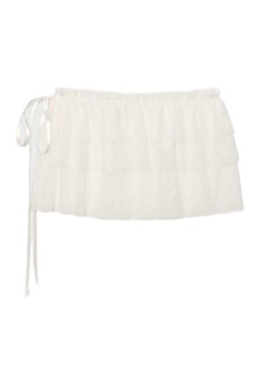 Mini-jupe blanche en dentelle superposée avec des volants et un détail de nouage latéral à la taille.