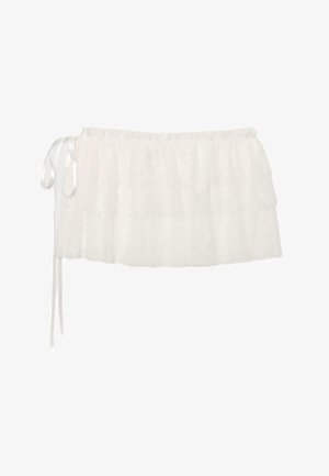 Mini-jupe blanche en dentelle superposée avec des volants et un détail de nouage latéral à la taille.