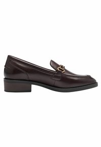 Mocassin en cuir marron foncé avec petit talon empilé et détail de boucle en métal doré sur le dessus, vue de côté sur fond blanc.
