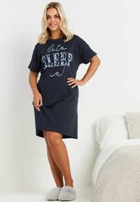 Mörkblå bomullsnattlinne med korta ärmar, med texten "låt oss SOVA in!" i fet stil. Matchas med mjuka gråtofflor, i avspänd passform.