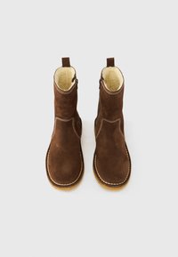 Ψηλοτάκουνα μπότες από σουέτ σε καφέ χρώμα με εκρού επένδυση, με στρογγυλεμένη μύτη και πλευρικό φερμουάρ, διακοσμημένες με αντίθετη ραφή και ευλύγιστη σόλα.