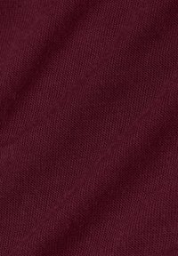 Tejido de punto burdeos con una textura fina, que presenta patrones en relieve diagonales y un aspecto suave y liso.