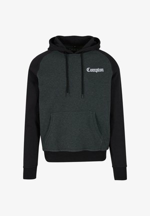 Tamsiai žalia ir juoda pūkų striukė su gobtuvu, su priekinėmis kengūrų kišenėmis ir balta siuvinėta "Compton" užrašu ant krūtinės.