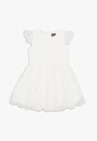 Vit spetsklänning med korta, svajande ärmar, figursydd bodice och utställd kjol. Texturerad spetsmönster och vågig fålldetalj.