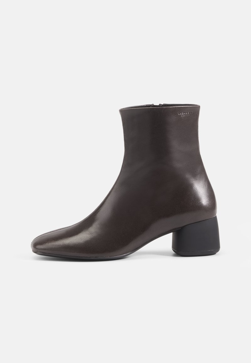 Brown leather ankle boot with a pointed toe and a block heel. Smooth texture, high shaft, and minimal hardware details.