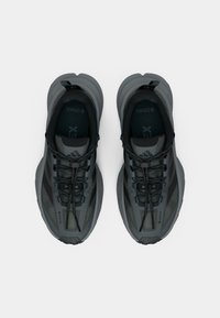 Γκρι αθλητικά παπούτσια με επάνω μέρος από πλέγμα, υφασμένα κορδόνια και λαστιχένιες σόλες. Διαθέτουν λογότυπο "Gore-Tex" για αντοχή στο νερό.