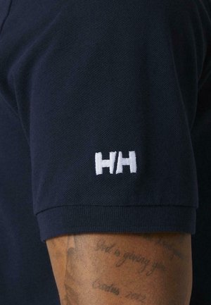 Donkerblauw poloshirt met een gestructureerde stof, voorzien van een wit geborduurd logo op de mouw. Het ontwerp heeft korte mouwen en een klassieke kraag.
