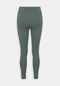 Zielone legginsy z wysokim stanem, wykonane z gładkiego, elastycznego materiału, bez wzorów czy ozdób. Prosty krój, pełnej długości.