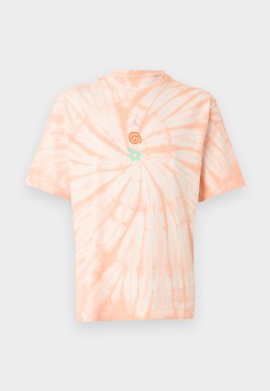 T-shirt tie-dye manches courtes en pêche douce et blanc avec de petits symboles spirales orange et soleil turquoise près de l'encolure.