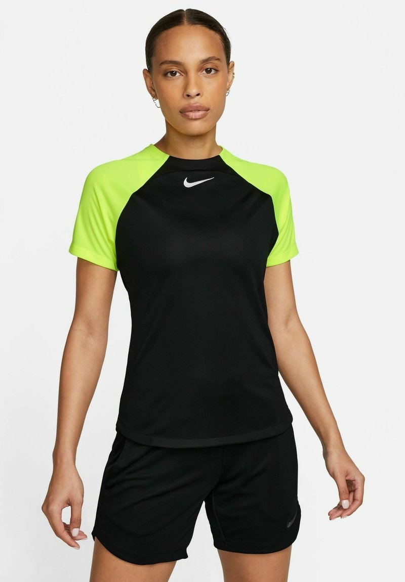 Maillot de sport noir à manches courtes avec des accents jaune fluo et un petit logo Nike blanc sur la poitrine. Associé avec un short noir.