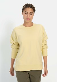 Lichtgele sweatshirt met ribbelboord bij de ronde hals, verlaagde schouders en lange mouwen. Zacht materiaal, losse pasvorm, met een subtiele logodetail.