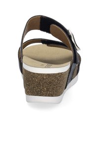 Sort sandal med korkkilehæl, der har en justerbar rem og polstret sål. Tekstureret ydersål for greb og holdbarhed.