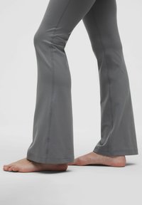 Harmaat leveät housut venyvästä kankaasta, jossa on tasaiset saumat ja sileä pinta, nilkkapituudella ja hieman levenevällä helman kohdalla.