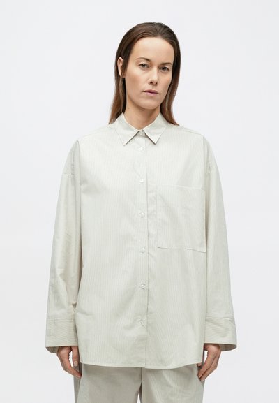 Világosszürke csíkos ing, hegyes nyakkal, hosszú ujjakkal és egyetlen mellkasi zsebbel, sima anyagból készült.