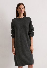 Robe en tricot surdimensionnée gris foncé avec un col rond et de longues manches retroussées. Texture lisse, longueur jusqu'aux genoux.