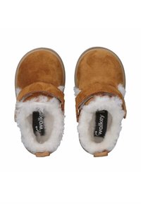 Bruine suède slippers met een witte pluche voering en een gespstrap. Rond toelopende vorm met een rubberen zool. Zwart merk zichtbaar aan de binnenkant.
