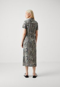 Paisley-patterned dress in a soft fabric. Short sleeves, cinched waist, mid-calf length. Shades of navy, green, and beige.