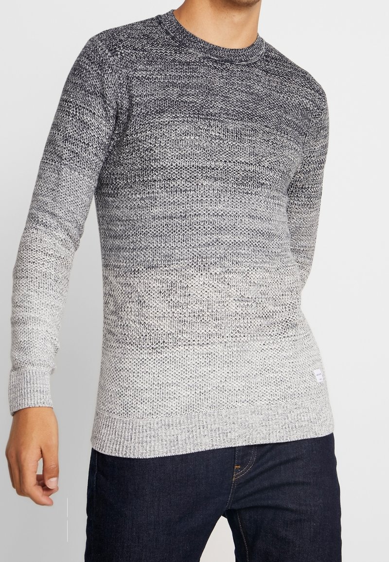 Stickad tröja med gradientdesign som övergår från mörkgrå till ljusgrå. Har rund halsringning och ribbade muddar och nederkant.