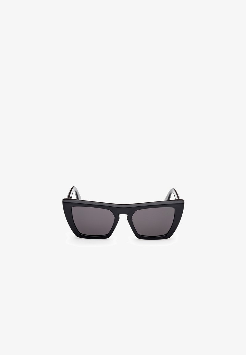 Black cat-eye sunglasses with dark lenses, featuring a thick, matte plastic frame and angular temples, designed with a minimalist aesthetic.