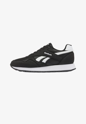 Zapatilla Reebok en blanco y negro con diseño de cordones y suela acolchada, vista de perfil sobre un fondo blanco.