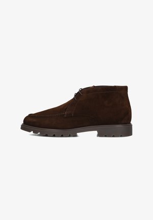Bruine suède chukka boots met een ronde neus, subtiele stiksels en een rubberen zool met gripnoppen. Vetersluiting.
