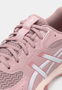 Ανοιχτό ροζ αθλητικό παπούτσι με επάνω μέρος από δίχτυ, κορδόνια στον ίδιο τόνο και λευκές λεπτομέρειες. Διαθέτει εύκαμπτη σόλα και υφή στην επιφάνεια για καλύτερη πρόσφυση.