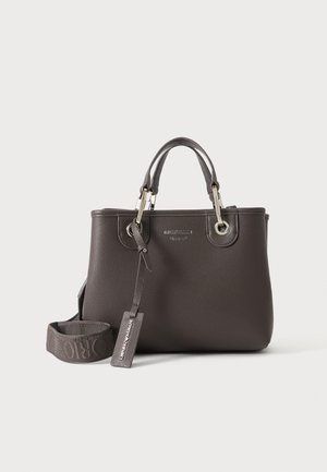 Dunkelgraue Lederhandtasche mit zwei Griffen, einem abnehmbaren breiten Schulterriemen und einem hängenden Anhänger mit Markennamen vor einem einfarbigen hellen Hintergrund.