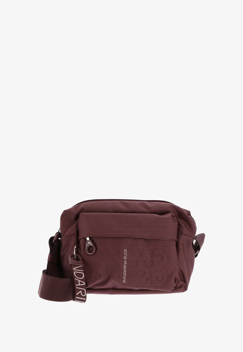 Sac bandoulière en tissu bordeaux avec surface texturée, compartiment principal zippé, poche avant et sangle ajustable. Détail de marque visible.