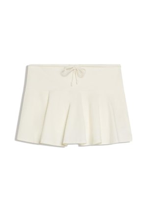 Mini-jupe plissée blanche avec une taille à cordon et un tissu doux et structuré, posée à plat sur un fond blanc.