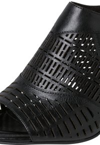 Chaussure noire à bout ouvert en cuir avec des motifs géométriques découpés, une texture lisse et un talon bas.