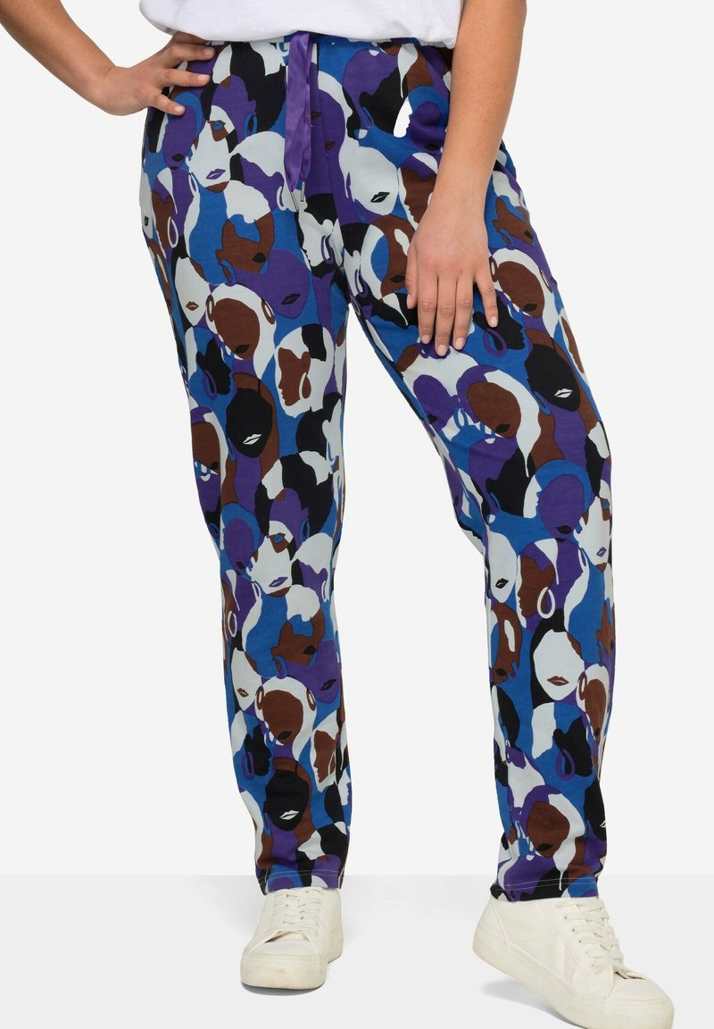Multicolore broek met een print van abstracte gezichten in blauwe, bruine en paarse tinten. Lichtgewicht stof, tapered fit, met een strikband.