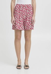 Pantaloni corti con motivo floreale dal taglio rilassato, realizzati in un tessuto morbido nelle tonalità di rosa e verde; vita elastica; lunghezza media fino alla coscia.