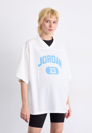 Balts acs tīkls džersijs ar īsām piedurknēm, uz kura ir zils teksts "JORDAN" un numurs "23". Saskaņots ar melniem velosipēdu šortiem.