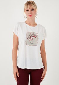 Witte T-shirt met korte mouwen met een bloemenprint in rood en grijs, gemaakt van zachte stof met een ontspannen pasvorm.