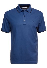 Polo en coton bleu marine avec une patte de boutonnage à trois boutons, un col en côtelé et des accents de manches dans une teinte plus foncée. Logo 'CK' brodé sur la poitrine.