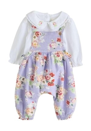 Valkoinen pitkähihaisen vauvan paita pitsikauluksella, päällä laventelinsävyinen kukkakuosinen haalari, jossa napit ja joustavat hihansuut.