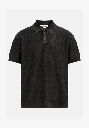 Musta lyhythihainen neulottu polopaita, jossa on kolmen napin läppä ja resorit kauluksessa, hihansuuissa ja helmassa, esillä yksinkertaisella taustalla.