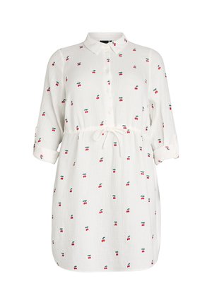 Bílé šaty s knoflíky a potiskem třešní, s rukávy ohrnutými do tří čtvrtin a páskem vázaným v pase.