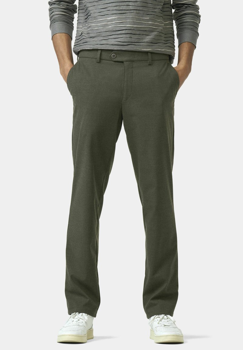 Olijfgroene broek met een gladde textuur, rechte snit en zijzakken. Gekleed met witte sneakers.