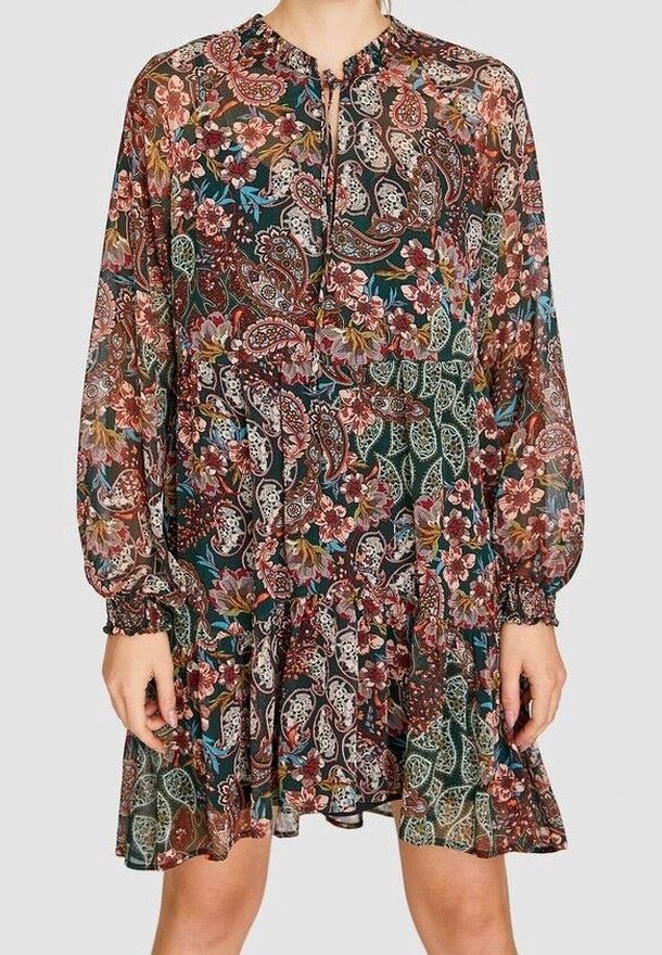 Robe à manches longues avec poignets froncés et jupe évasée avec un imprimé floral et cachemire multicolore sur tissu foncé.