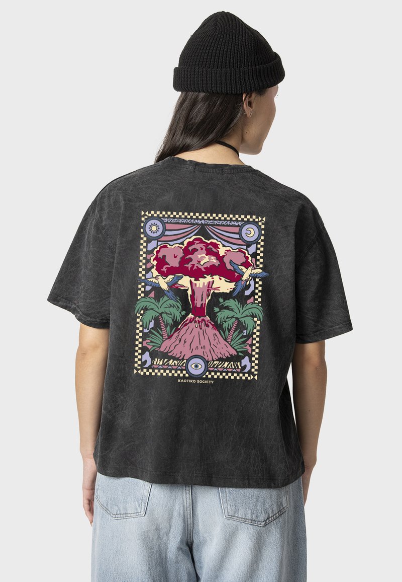 Camiseta de algodón gris con un corte relajado, que presenta un gráfico colorido de un volcán en erupción y palmeras en la parte posterior.