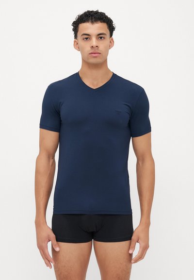 Navyblauw T-shirt met korte mouwen en V-hals, gemaakt van zachte stof. Kenmerkt zich door een slim fit ontwerp, een gladde textuur en subtiele branding op de borst.