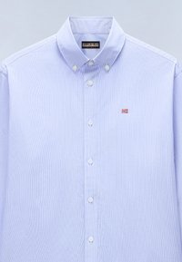 Light blue button-up shirt with vertical white stripes, a button-down collar, and a small Norwegian flag emblem on the chest.