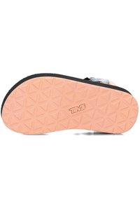 Suela negra y rosa con patrón de banda de rodadura geométrica. Presenta un logo de Teva en relieve en el lateral y una superficie texturizada para mayor agarre.