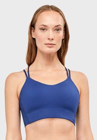 Sujetador deportivo azul hecho de tela suave y elástica. Cuenta con dos tirantes delgados y un diseño corto. Construcción sin costuras para mayor comodidad.