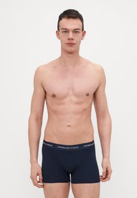 Sötétkék boxer alsónadrág, puha tapintással, elasztikus derékpánttal, amelyen fehér színű "COPENHAGEN STUDIOS" felirat látható, testhezálló fazonban, tiszta vonalakkal.