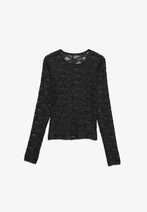 Top nero in pizzo manica lunga con motivo floreale, scollo rotondo e tessuto semi-trasparente, disteso su sfondo bianco.
