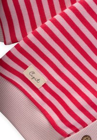 Sweter w paski z naprzemiennymi szerokimi czerwonymi i różowymi paskami, prążkowana tekstura przy mankietach oraz mała metka z napisem "Cigt" na beżowym tle.